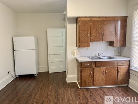 A kitchen with wooden cabinets and a white fridge.