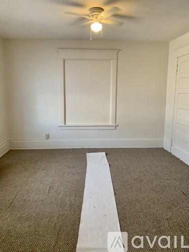 A room with a white wall and a carpeted floor.