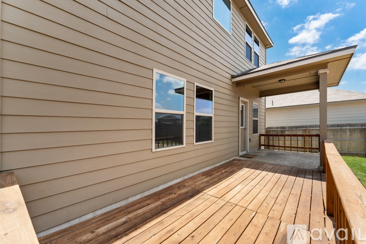 A wooden deck with a bench and a small porch area.