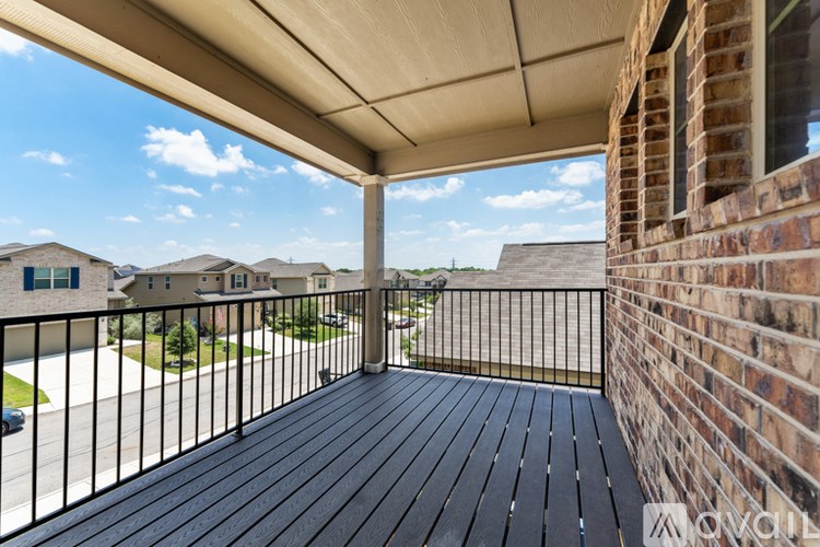 A balcony with a black railing and a wooden floor.