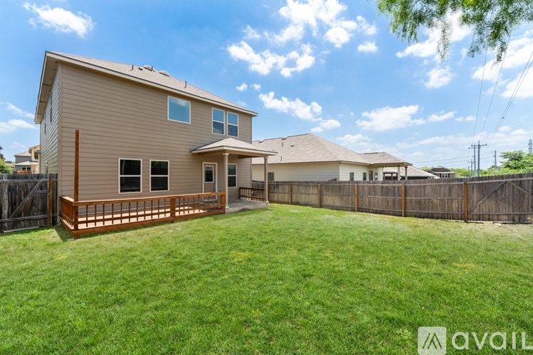 A house with a brown fence and a green lawn.
