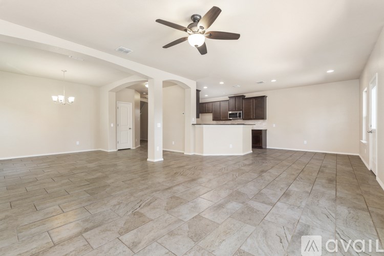 A spacious room with a ceiling fan and tiled flooring.