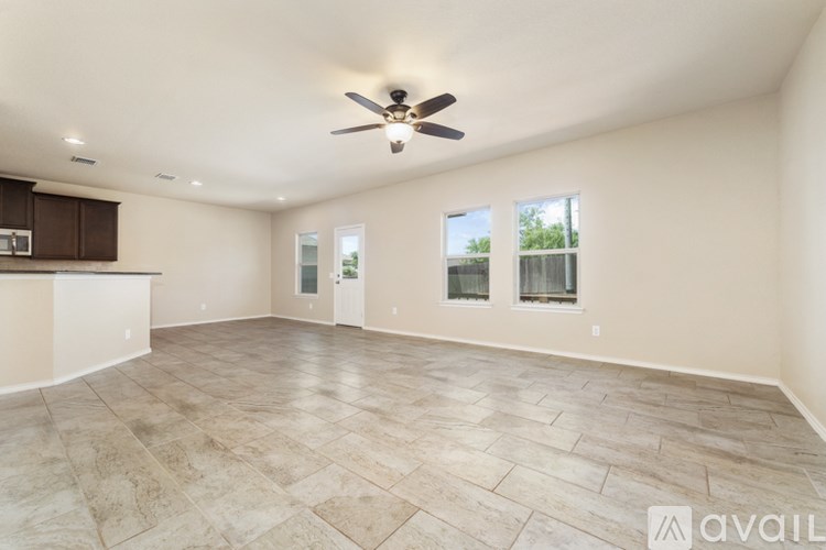 A spacious room with a ceiling fan and tiled flooring.