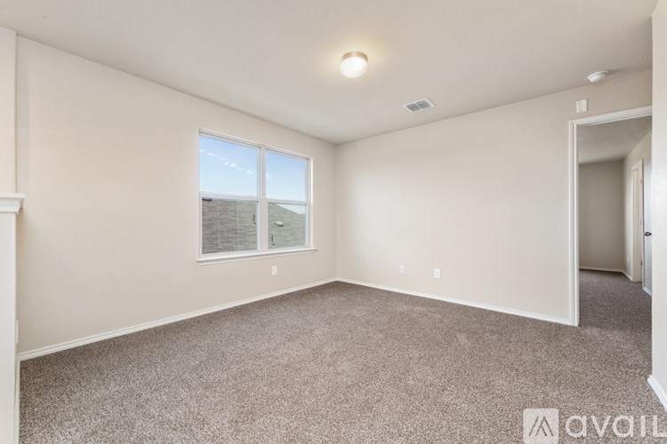 Empty room with a window and carpeted floor.