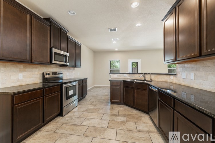 A kitchen with brown cabinets and a tile floor.
