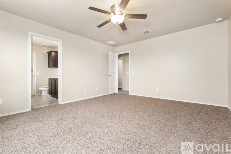 A spacious room with a ceiling fan and carpeted floor.