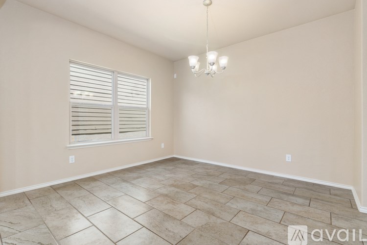 A room with tiled flooring and a window with blinds.