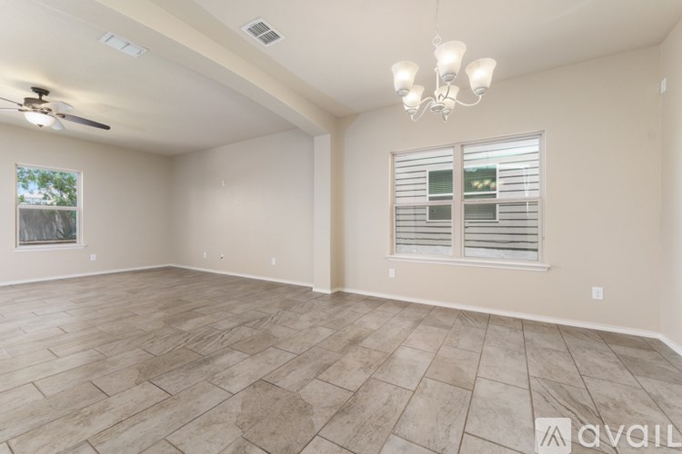 A spacious room with a ceiling fan and a window with blinds.