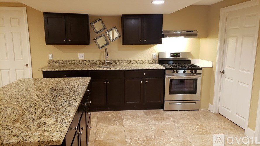 A kitchen with granite countertops and a stainless steel oven.
