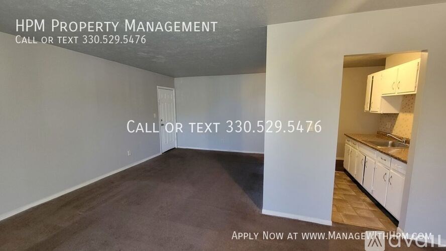 A room with a kitchen area is on the right side of the image, and the left side shows an empty room.