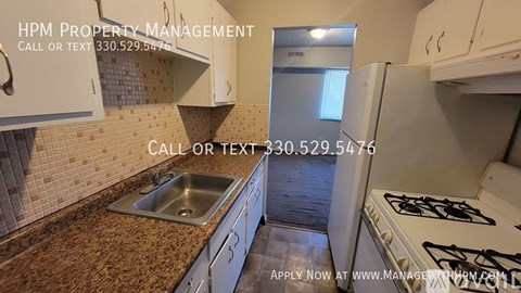 A kitchen with a countertop, sink, and cabinets is shown with an advertisement for HPM Property Management.
