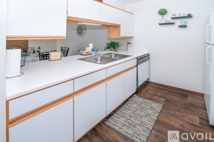 A kitchen with white cabinets and a wooden counter top.