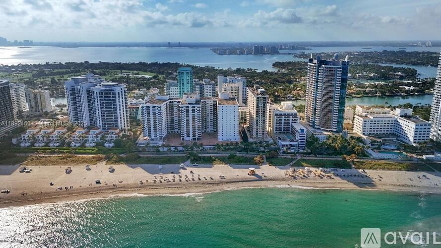 A beachfront cityscape with a clear sky and calm sea.