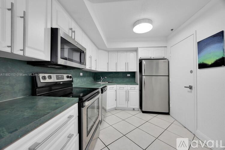 A kitchen with white cabinets and black appliances.