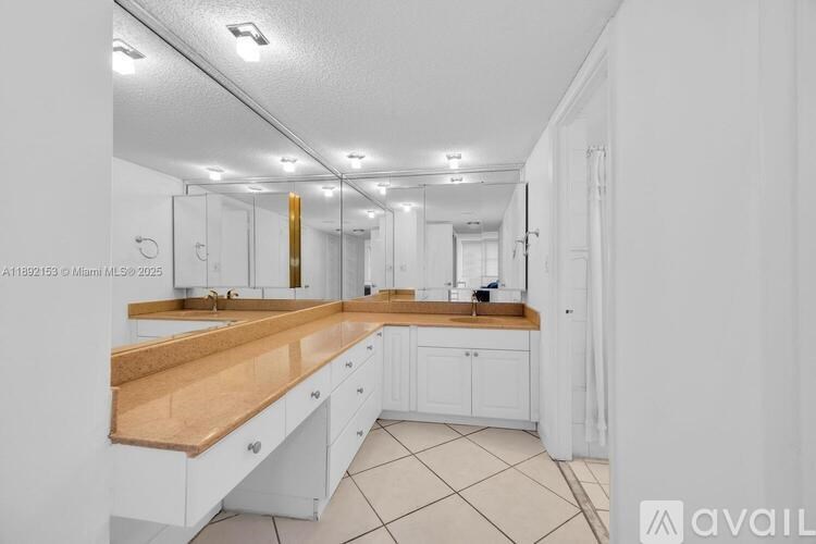 A kitchen with white cabinets and a wooden countertop.