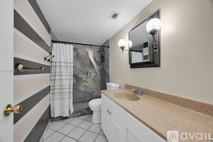 A bathroom with a striped wallpaper on the wall.