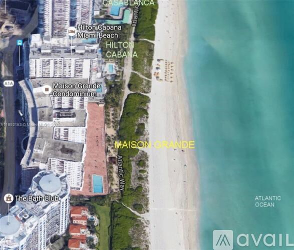 An aerial view of a beachfront area with the text "MAISON GRANDE" prominently displayed.