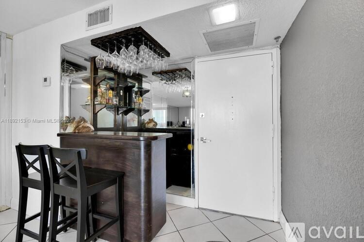 A kitchen with a bar area and a white door.