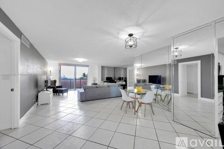 A spacious living room with a dining area and a kitchen in the background.