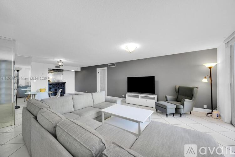 A modern living room with a grey sofa set and a white coffee table.