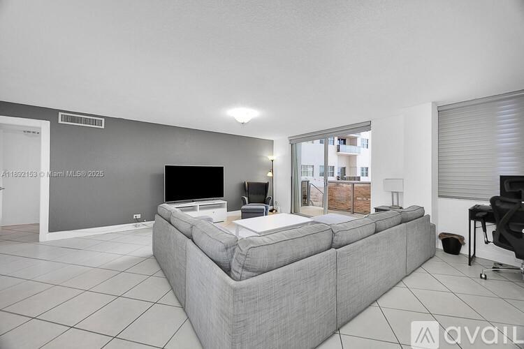 A living room with a grey couch and a television.