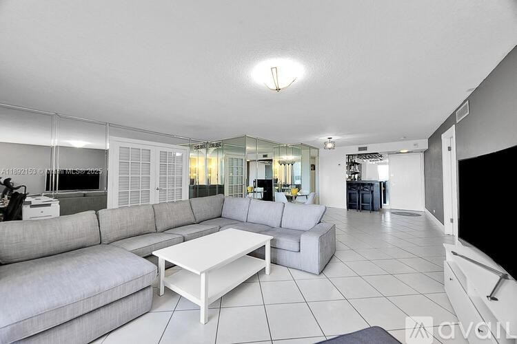 A living room with a grey sofa and a white coffee table.