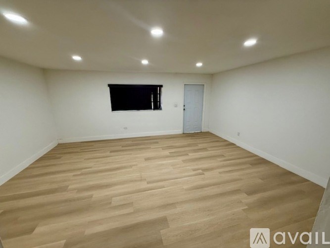 A room with wooden flooring and a window.