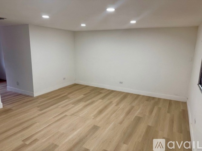 A room with wooden flooring and white walls.