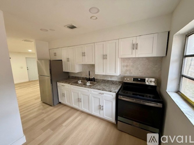 A kitchen with white cabinets and a black stove top oven.
