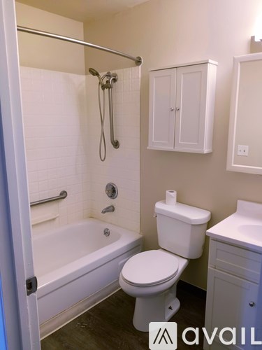 A white toilet sits next to a bathtub in a bathroom.