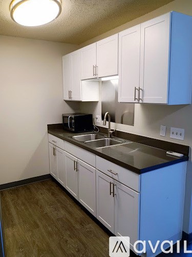 A kitchen with white cabinets and a blue island.