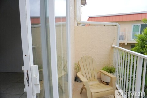 A wooden chair is placed on a balcony.