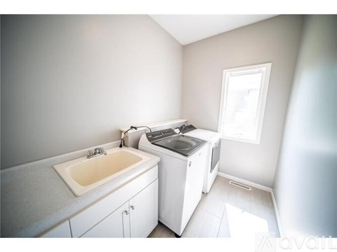 A small white kitchen with a sink and a dishwasher.