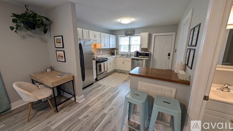 A kitchen with a table and chairs and a fridge.