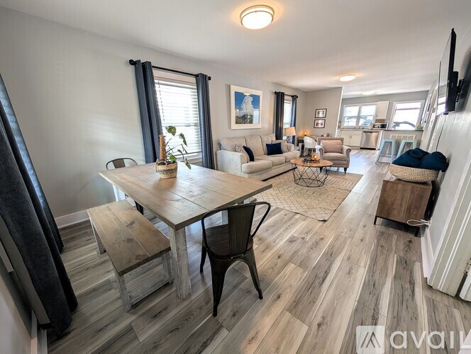 A living room with a wooden floor and furniture.
