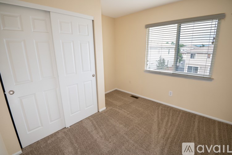 A room with a white door and a window with blinds.