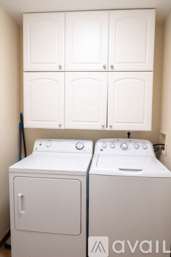 A white washing machine and dryer in a laundry room.