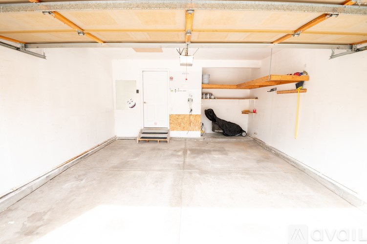 A room with a white door and a white wall with a wooden beam on the ceiling.