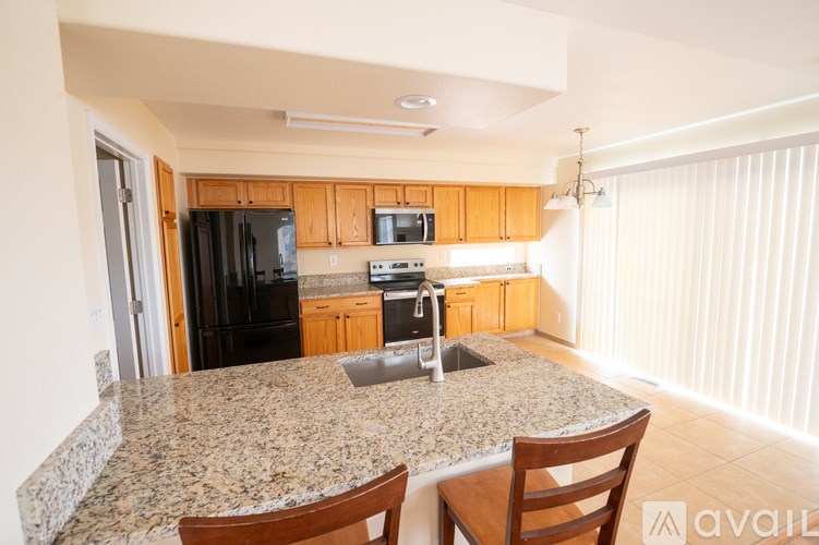 A kitchen with granite countertops and wooden cabinets.