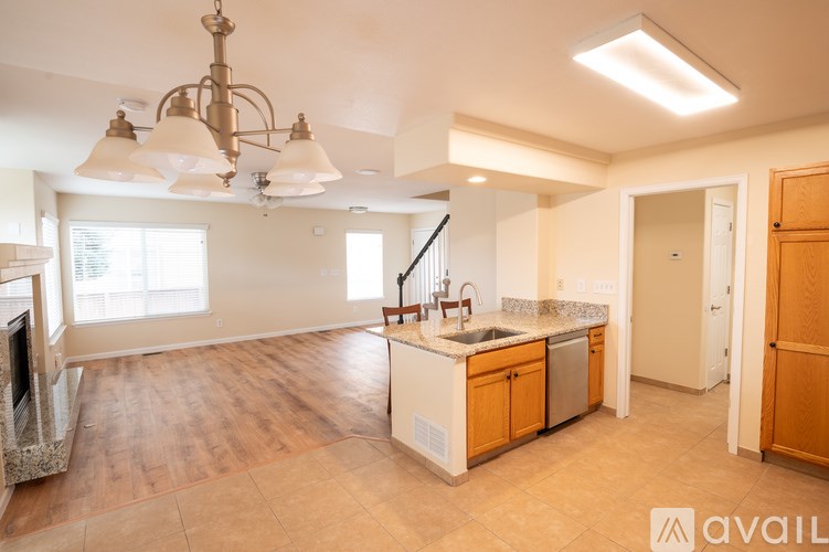 A kitchen with wooden floors and a chandelier.
