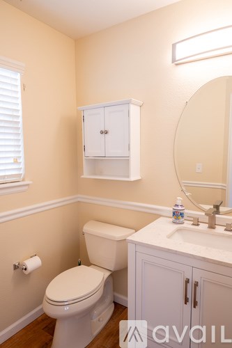 A bathroom with a toilet, sink, and medicine cabinet.