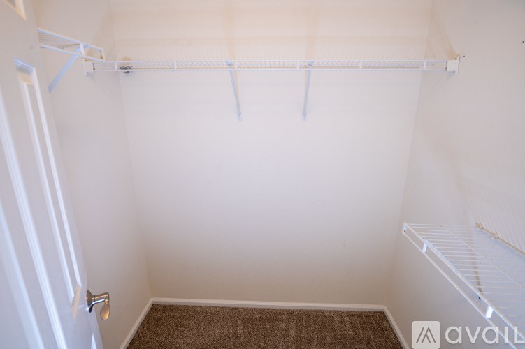 A small, empty room with a carpeted floor and a door on the left.