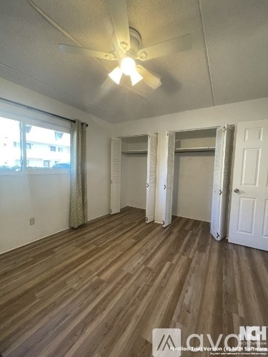 A room with wooden flooring and white walls.