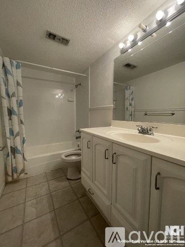 A bathroom with a toilet, sink, and mirror.