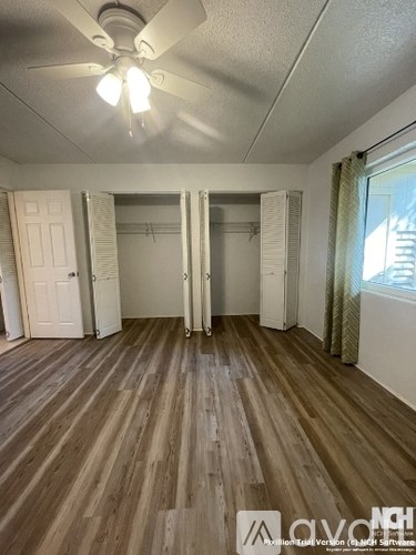 A room with wooden flooring and a ceiling fan.