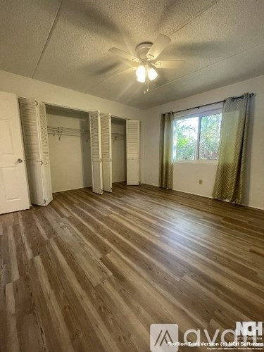 A room with wooden flooring and a ceiling fan.