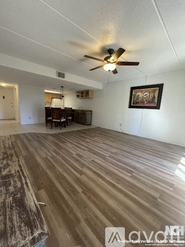 A room with a ceiling fan and wooden flooring.