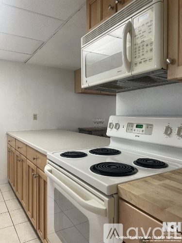 A white stove top oven with four burners and a microwave above it.
