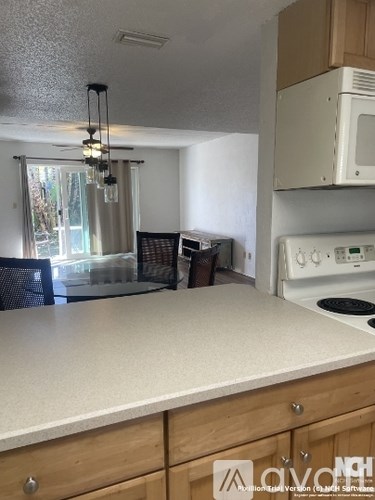 A kitchen with a white counter top and a white oven.
