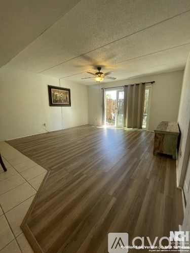 A room with wooden flooring and a ceiling fan.